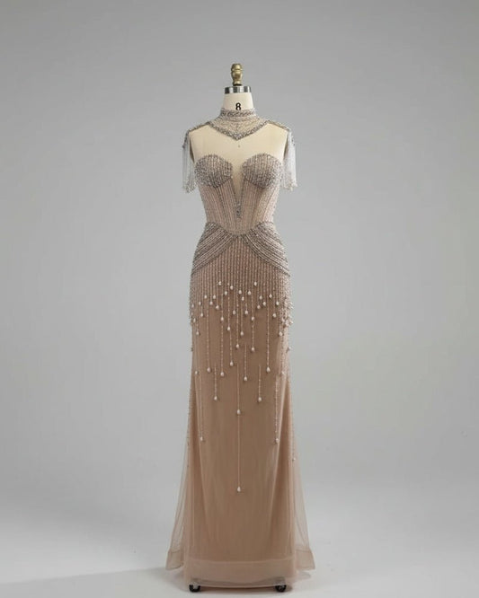 Beaded evening gown on a mannequin against a white paneled wall.