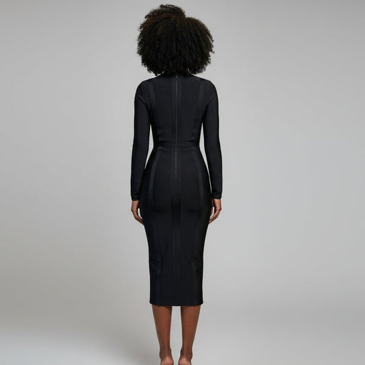 Woman in a black dress standing in a stylish room with brown chairs and large windows.