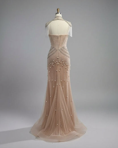 Beaded evening gown on a mannequin in a room with white walls and wooden floor.