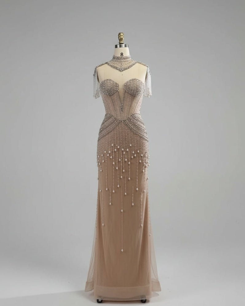 Beaded evening gown on a mannequin against a white paneled wall.