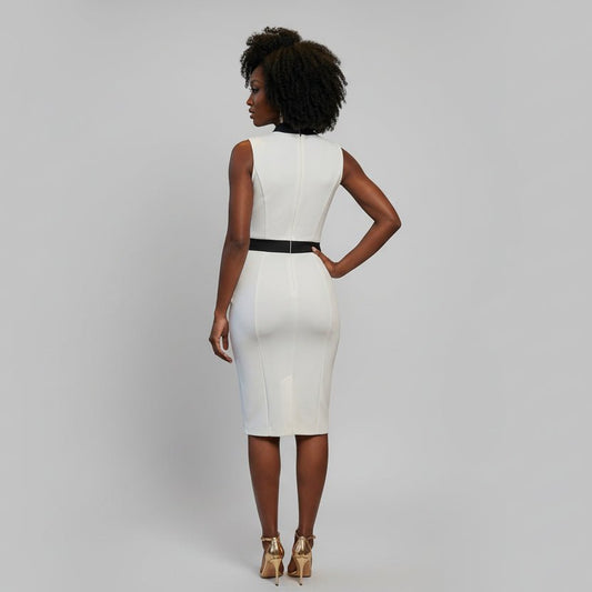 Woman in a white dress standing in a stylish room with brown chairs and city view.