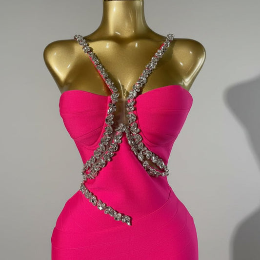 Pink dress with a decorative back on a mannequin against a metallic background